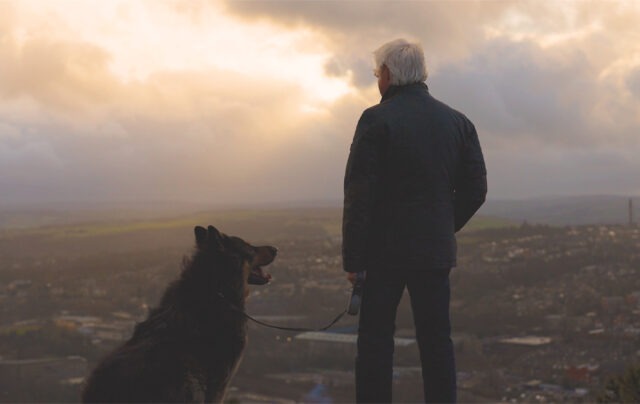 Jim stood with his dog on a hill