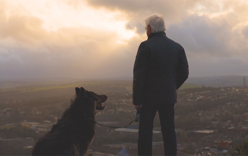 Jim stood with his dog on a hill