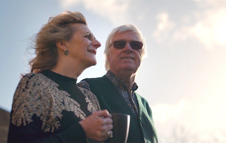 Couple outside holding a mug