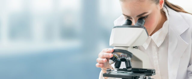 Scientist looking through magnifying glass