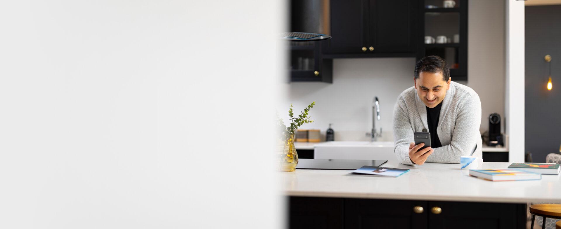 Male using phone in kitchen